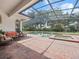 Screened-in pool features brick pavers, built-in spa, waterfall features, and comfortable outdoor seating at 8531 Cypress Hollow Ct, Sanford, FL 32771