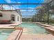Sparkling screened-in pool features brick pavers, built-in spa, waterfall features, and outdoor seating at 8531 Cypress Hollow Ct, Sanford, FL 32771