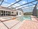 Screened-in pool features brick pavers, built-in spa, waterfall features, and views of the home's exterior at 8531 Cypress Hollow Ct, Sanford, FL 32771