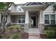 Inviting front porch with stone pillars and an open door showcasing the home's interior at 8670 Vedder Ln, Orlando, FL 32832