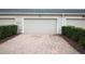 Two-car garage with a paved driveway, offering ample parking and curb appeal at 8670 Vedder Ln, Orlando, FL 32832