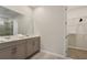 Bathroom featuring a double vanity, walk-in shower and large walk-in closet at 8928 Coconut Breeze Dr, Kissimmee, FL 34747