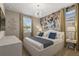 Bedroom with a king sized bed, modern furniture, floral wall coverings and neutral decor at 8928 Coconut Breeze Dr, Kissimmee, FL 34747