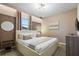 Bright bedroom boasts a modern bed frame, stylish wall decor, and ample natural light from large windows at 8928 Coconut Breeze Dr, Kissimmee, FL 34747