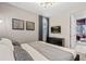 Well-lit bedroom featuring a mounted television and an open doorway to another living space at 8928 Coconut Breeze Dr, Kissimmee, FL 34747