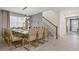 Elegant dining room with a modern chandelier, seating for ten, and easy access to the stairs and entry hall at 8928 Coconut Breeze Dr, Kissimmee, FL 34747