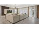 Spacious living room features a large sectional, elegant curtains, and a sliding glass door to the outdoor area at 8928 Coconut Breeze Dr, Kissimmee, FL 34747