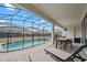 Screened-in pool area with hot tub, patio seating, and -safety fence create a relaxing backyard retreat at 8928 Coconut Breeze Dr, Kissimmee, FL 34747
