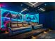Home theater features tiered seating with plush couches, custom lighting and a space themed wall mural at 8928 Coconut Breeze Dr, Kissimmee, FL 34747