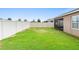 Spacious backyard with a white fence, lush green lawn, and a view of the screened lanai at 927 Denali Dr, Orange City, FL 32763