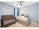 Cozy bedroom features a crib, daybed, and ceiling fan at 927 Denali Dr, Orange City, FL 32763