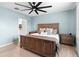 Light blue bedroom with wooden bed, ceiling fan, and view to the bathroom at 927 Denali Dr, Orange City, FL 32763