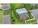 Aerial view of a community pool with ample seating, surrounded by lush landscaping and palm trees at 927 Denali Dr, Orange City, FL 32763
