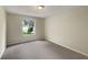 Neutral bedroom featuring gray carpet, light walls, a window and a ceiling light at 9514 Se 168Th Maplesong Ln, The Villages, FL 32162