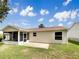 The back of this beige home showcases an enclosed porch, patio, and neatly kept lawn at 9514 Se 168Th Maplesong Ln, The Villages, FL 32162