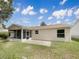 The back of this beige home showcases an enclosed porch, patio, and neatly kept lawn at 9514 Se 168Th Maplesong Ln, The Villages, FL 32162
