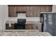 Well-equipped kitchen featuring granite countertops, wooden cabinets, and modern black appliances, creating a functional and stylish space at 1206 Beechdale Ct, Deltona, FL 32725