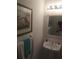 Bathroom with pedestal sink, framed mirror, and decorative wall art at 13200 Mallard Cove Blvd, Orlando, FL 32837