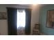 Bedroom with a chair, dark curtains and art on the walls at 13200 Mallard Cove Blvd, Orlando, FL 32837