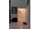 Hallway with white tile floor and neutral paint, featuring artwork and multiple doorways at 13200 Mallard Cove Blvd, Orlando, FL 32837
