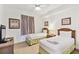 Bright bedroom with twin beds, tropical-themed decor, a ceiling fan, and a woven accent table at 13427 Blue Heron Beach Dr # 404, Orlando, FL 32821