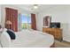 Comfortable bedroom features large windows overlooking the water and nice wood dresser at 13427 Blue Heron Beach Dr # 404, Orlando, FL 32821