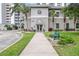 The front entrance of the community building featuring well-maintained landscaping, benches and a covered entryway at 13427 Blue Heron Beach Dr # 404, Orlando, FL 32821