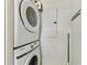 A stacked, front-load washer and dryer set sit against a wall with a utility panel at 13427 Blue Heron Beach Dr # 404, Orlando, FL 32821