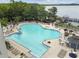 Aerial view of a large community pool and lakeside pier, perfect for leisure and enjoying the surrounding nature at 13427 Blue Heron Beach Dr # 404, Orlando, FL 32821
