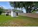 The spacious backyard features a shed, lush greenery, and a partial fence for privacy at 1447 Candlewyck Dr, Orlando, FL 32807