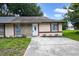 Charming single-story home featuring a stone facade, white door, and concrete driveway at 1447 Candlewyck Dr, Orlando, FL 32807
