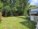 A partially shaded backyard showcasing lush greenery and a peaceful atmosphere, perfect for relaxation at 1525 Hilltop Rd, Casselberry, FL 32707