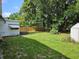Spacious backyard featuring lush green grass, mature trees, and a wooden fence for privacy at 1525 Hilltop Rd, Casselberry, FL 32707
