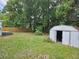 Lush backyard featuring ample greenery and a small storage shed, offering practical storage solutions and outdoor space at 1525 Hilltop Rd, Casselberry, FL 32707