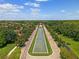 Aerial view showcasing a grand entrance and a tranquil street lined with lush trees and beautiful landscaping at 15647 Braintree Ln, Winter Garden, FL 34787