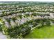 Aerial view of a neighborhood with mature trees, and a scenic pond at 15647 Braintree Ln, Winter Garden, FL 34787