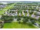 Aerial view of a neighborhood with mature trees, and a scenic pond at 15647 Braintree Ln, Winter Garden, FL 34787