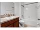 Clean bathroom with white tiled shower, white toilet, and a vanity with a brown cabinet at 15647 Braintree Ln, Winter Garden, FL 34787