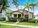 Charming single-story home with a well-manicured lawn, lush landscaping, and inviting front porch at 15647 Braintree Ln, Winter Garden, FL 34787