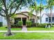 Charming single-story home with a well-manicured lawn, lush landscaping, and inviting front porch at 15647 Braintree Ln, Winter Garden, FL 34787