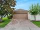 Attached garage with brick paver driveway and mature landscaping at 15647 Braintree Ln, Winter Garden, FL 34787