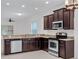 Modern kitchen featuring granite countertops, dark cabinets, and stainless steel appliances at 15647 Braintree Ln, Winter Garden, FL 34787