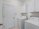 A laundry room equipped with appliances and storage cabinets at 15647 Braintree Ln, Winter Garden, FL 34787