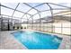 This screened in pool features a spa, a small waterfall, and brick pavers at 1625 Nassau Point Trl, Kissimmee, FL 34747