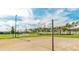 Sandy volleyball court with net in place, surrounded by palm trees and green space for outdoor recreation at 1625 Nassau Point Trl, Kissimmee, FL 34747