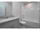 Well-lit bathroom features a granite countertop and a tiled shower over the tub at 17363 Million Lakes Ct, Clermont, FL 34714
