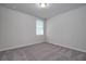 Clean, carpeted bedroom with a large window allowing natural light, creating a serene and inviting atmosphere at 17363 Million Lakes Ct, Clermont, FL 34714