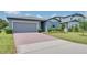 Inviting single-story home with a brick driveway, lush green lawn, and a well-maintained exterior at 17363 Million Lakes Ct, Clermont, FL 34714