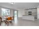 Open-concept living area with wood-look flooring, stainless appliances, and abundant natural light from large windows at 17363 Million Lakes Ct, Clermont, FL 34714