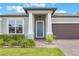 Inviting front entry with a blue door, manicured shrubs, and a brick paved walkway at 1740 Standing Rock Cir, Oakland, FL 34787